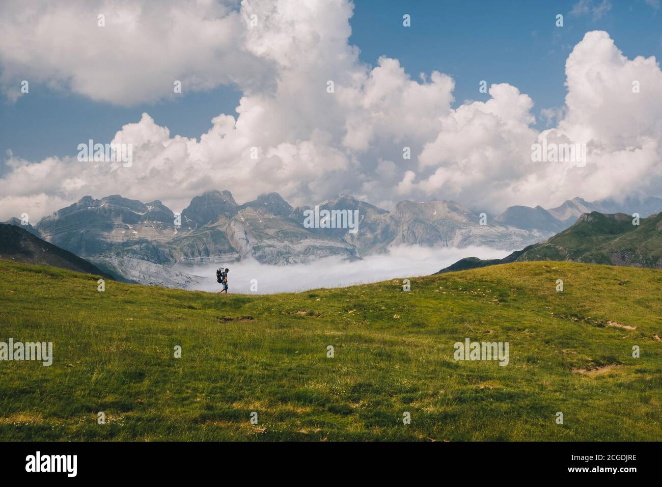 Der junge Mann wandert am Fuße des Berges Aspe in den Pyrenäen, während er seinen Sohn im Träger trägt. Huesca, Spanien Stockfoto