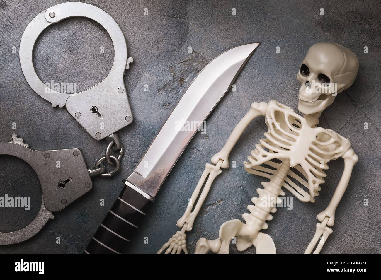 Handschellen, Messer und menschliches Skelett, Draufsicht. Konzept der Bestrafung für das Verbrechen Stockfoto