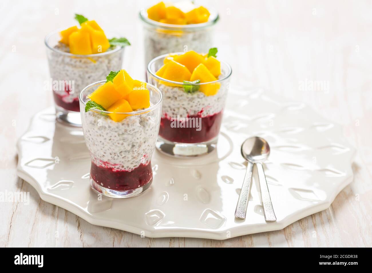 Gesunder Chia-Samenpudding mit Joghurt, Himbeer-Mousse und frischer Mango Stockfoto
