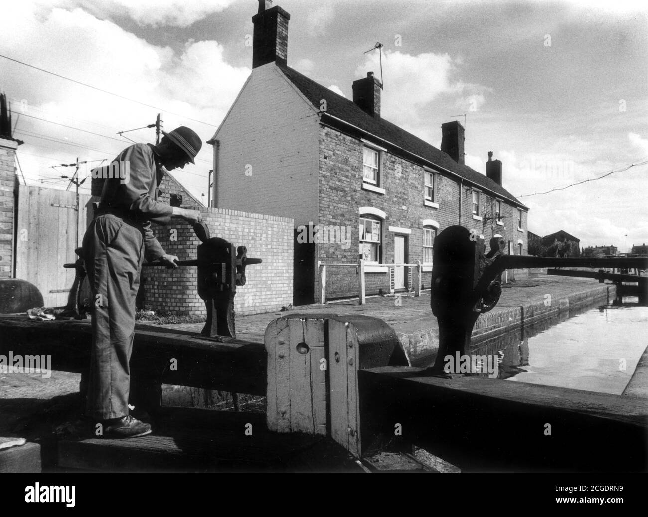 Der Schleusenwärter, der die Schleusentore auf 21 Schleusenflug Wolverhampton, Birmingham Old Main Line Canal einölt Stockfoto