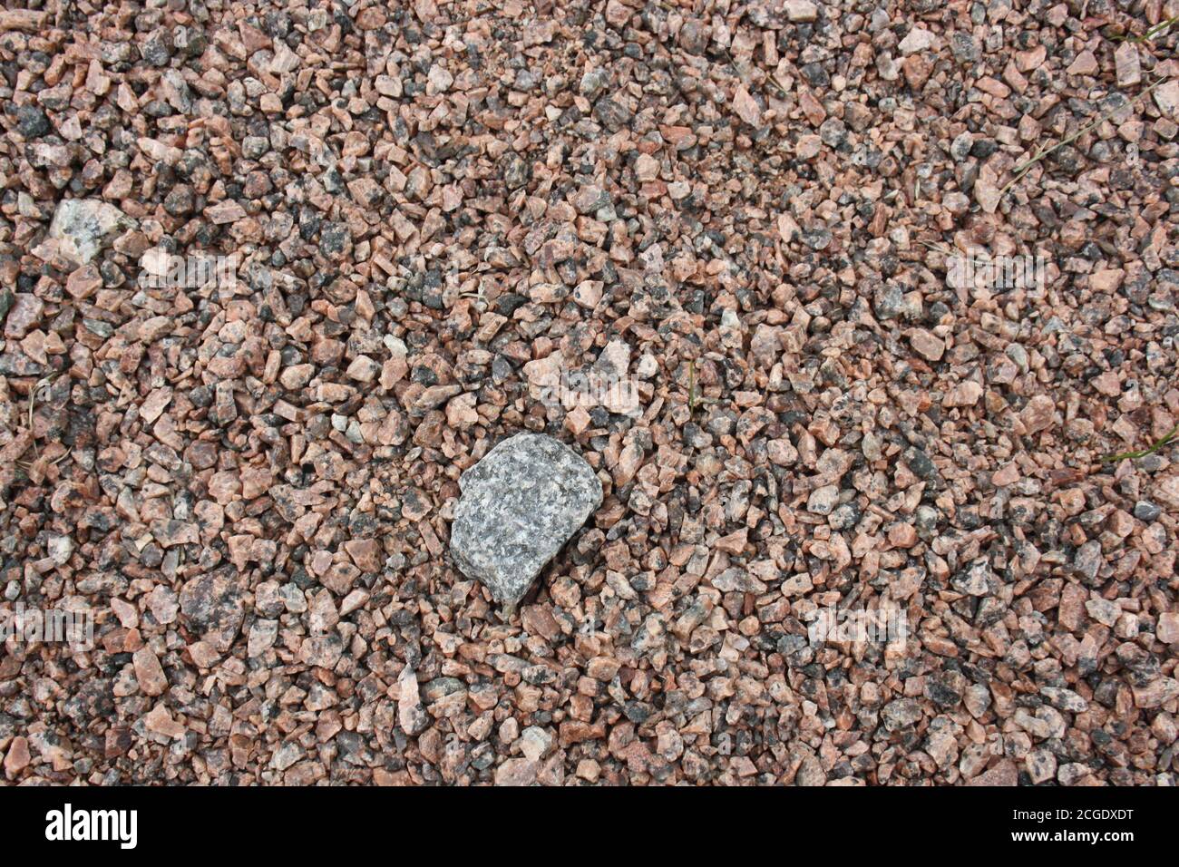 Stein auf einem Hintergrund von grobem Sand, Kieselsteine Nahaufnahme. Hintergrund. Stockfoto