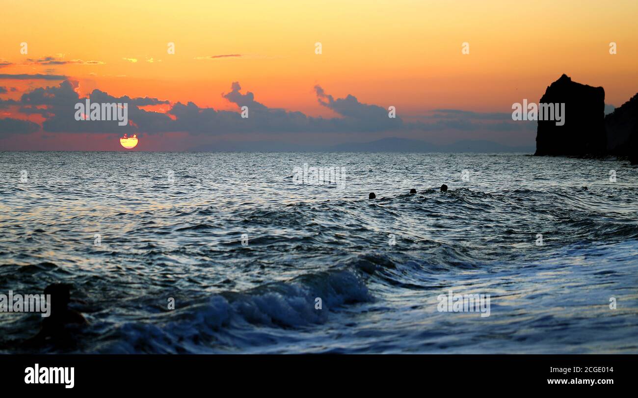 Foto von einem schönen Felsen und raues Meer bei Sonnenuntergang. Die Förderung des Tourismus im Meer. Stockfoto