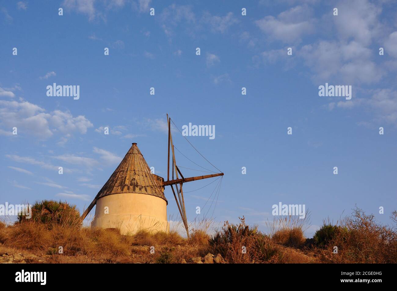 Alte, weiße Windmühle in der Nähe von San Jose. Wunderschöne Landschaft im Naturpark Cabo de Gata, Almeria, Spanien Stockfoto