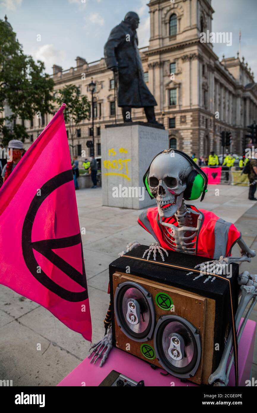 London, Großbritannien. September 2020. Die Churchill-Statue ist mit den Worten "ist ein Rassist" bemalt, obwohl dies nicht als Teil des XR-Protests behauptet wurde - Es ist der letzte offizielle Tag der aktuellen Rebellion-Proteste vom Aussterben und als der märz auf dem Parliament Square ankommt, findet es das rosa XR-Boot, Tell the Truth wurde bereits von der Polizei abgesperrt. Masken werden im Allgemeinen getragen und soziale Distanzierung praktiziert, da die Lockerung für den Coronavirus-Ausbruch (Covid 19) in London fortgesetzt wird. Kredit: Guy Bell/Alamy Live Nachrichten Stockfoto