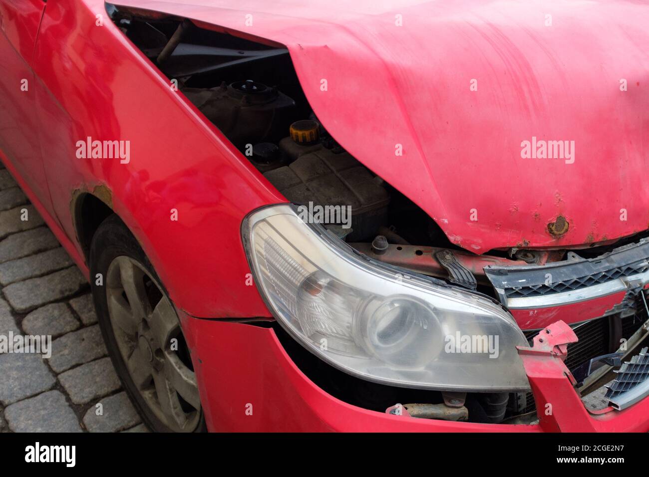 Rotes Auto mit kaputter Haube. Nahaufnahme Stockfoto