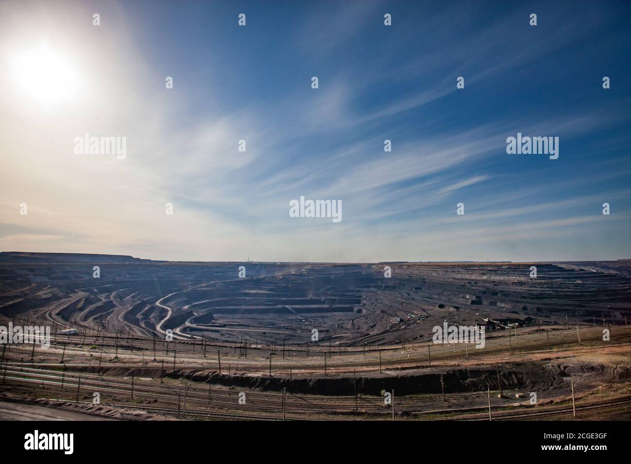 Tagebaugewinnung von Kohle im Steinbruch "Bogatyr", Ekibastuz, Kasachstan. Bagger, Bagger und Zug. Weitwinkelpanorama. Blauer Himmel mit Wolken. Stockfoto