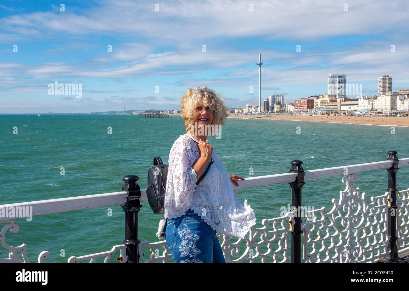 Reife Frau weiblich auf Brighton Palace Pier während Coronavirus COOVID-19 Pandemie Stockfoto