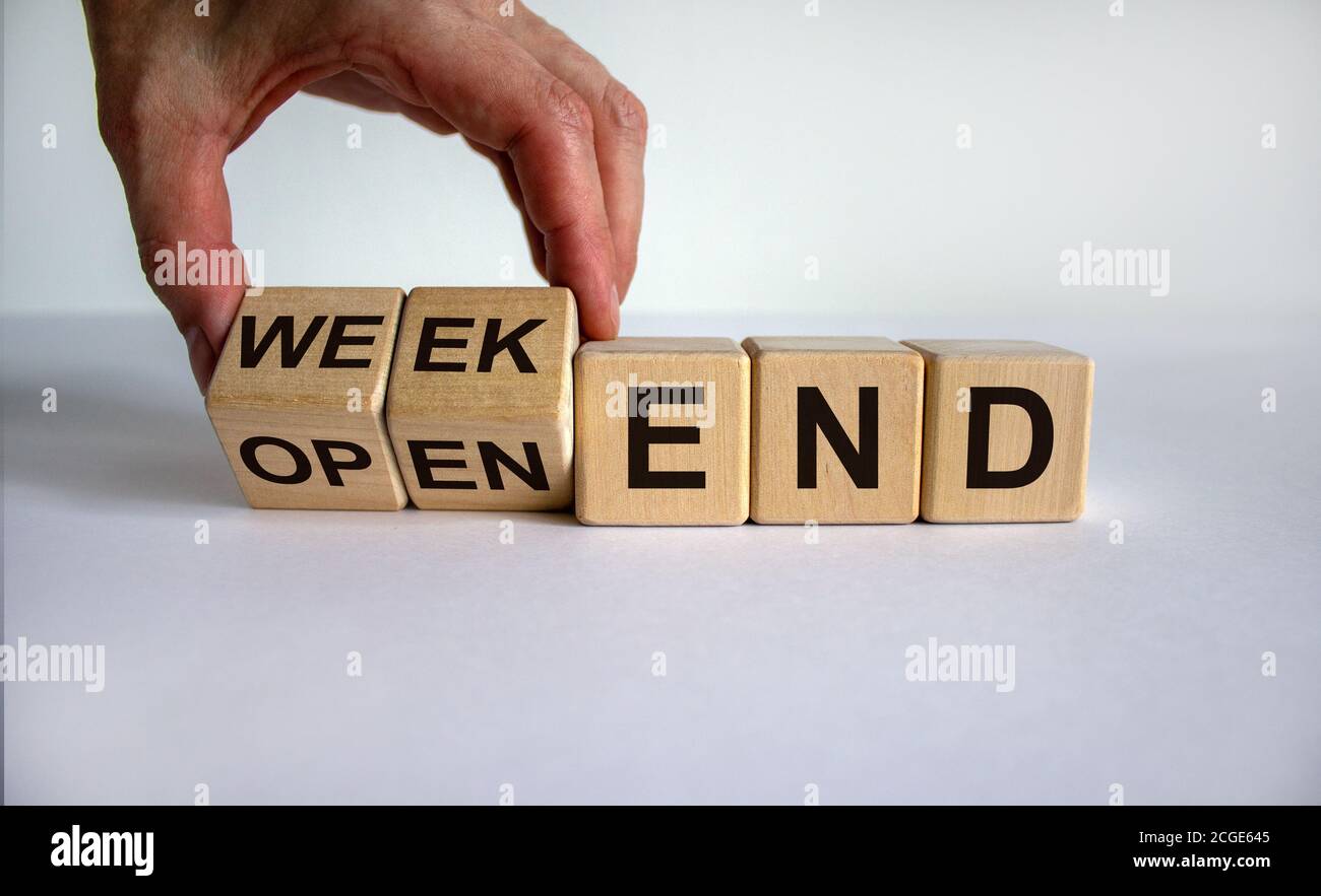 Hand dreht einen Würfel und ändert den Ausdruck 'open-end' in 'weekend'. Schöner weißer Hintergrund. Geschäftskonzept. Speicherplatz kopieren. Stockfoto