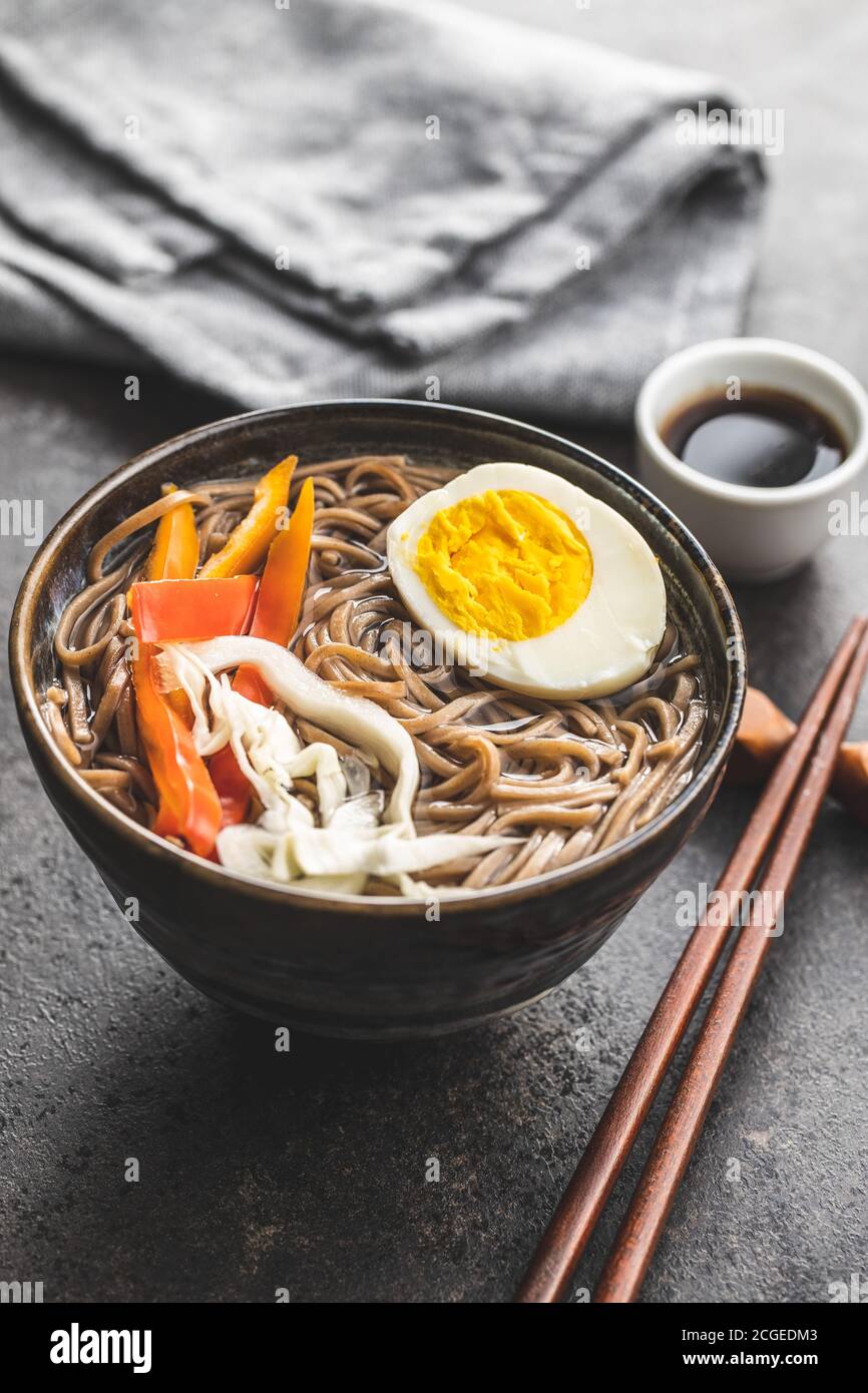 Asiatische Nudelsuppe mit Soba-Nudeln, Gemüse und Ei in einer Schüssel. Stockfoto