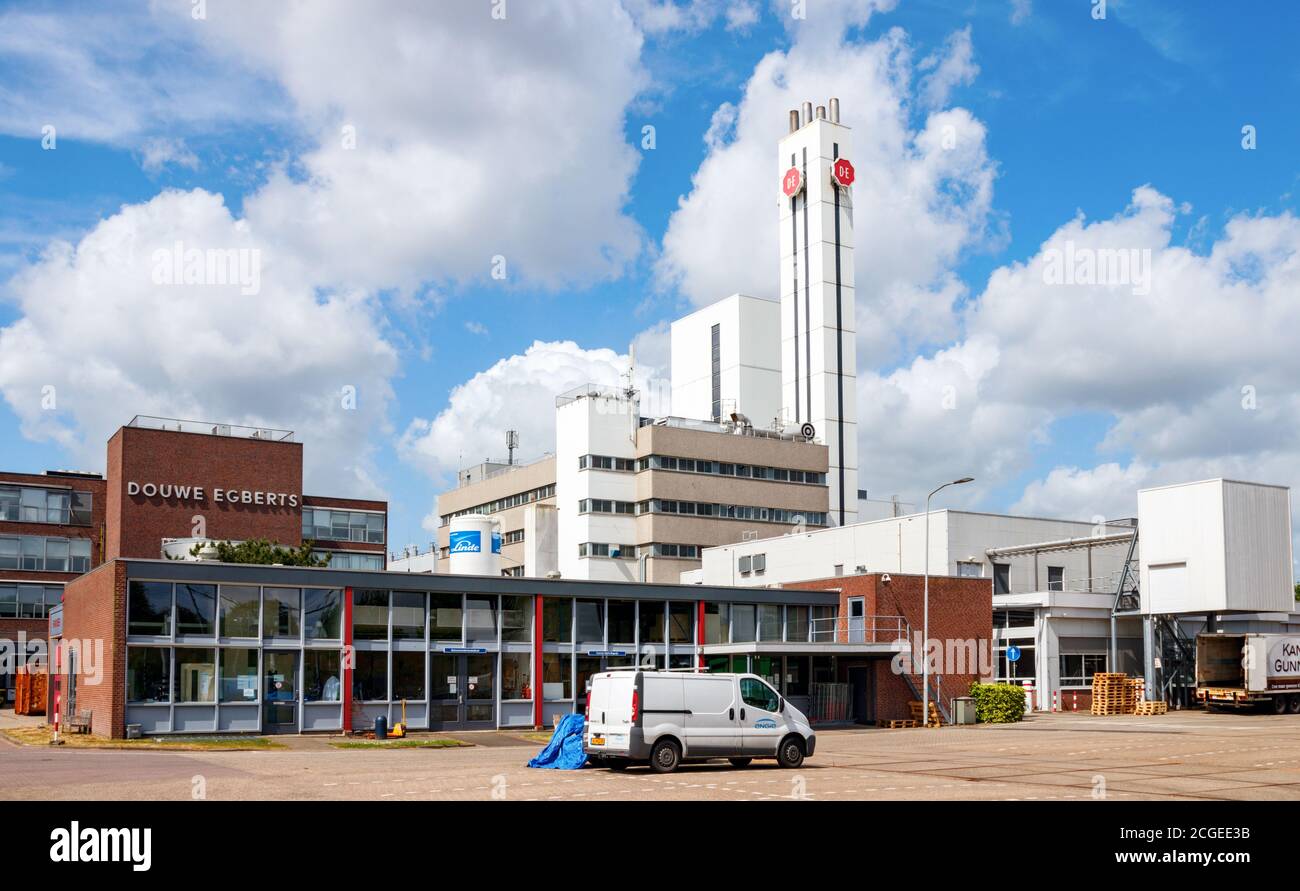 Bürogebäude und Kamin der Jacobs Douwe Egberts Kaffeerösterei unter blauem Himmel mit Wolken. Utrecht, Niederlande. Stockfoto Bürogebäude und Kamin der Jacobs Douwe Egberts Kaffeerösterei unter blauem Himmel mit Wolken. Utrecht, Niederlande. Stockfoto