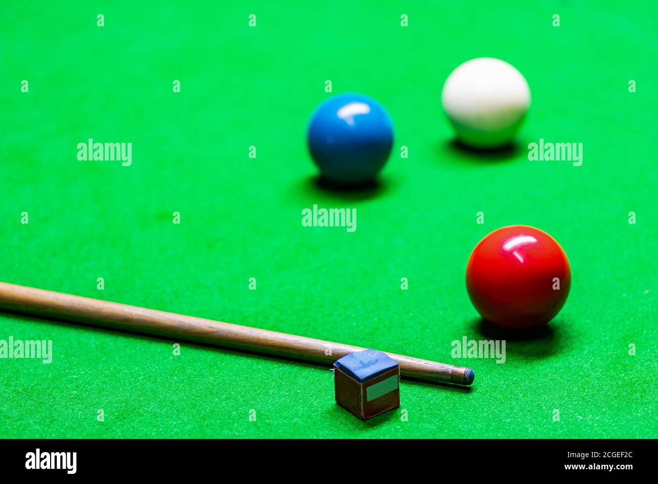 Ein Queue und Snooker-Kugeln in verschiedenen Farben werden auf dem Snooker-Tisch platziert. Stockfoto