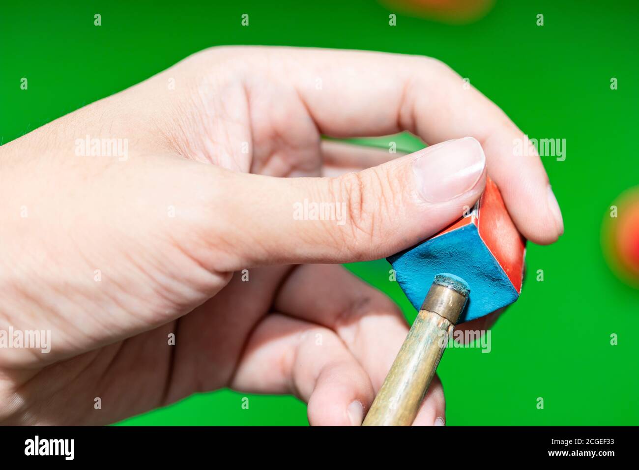Nahaufnahme Hand Player Snooker mit Kreide Reiben ein Queue. Stockfoto