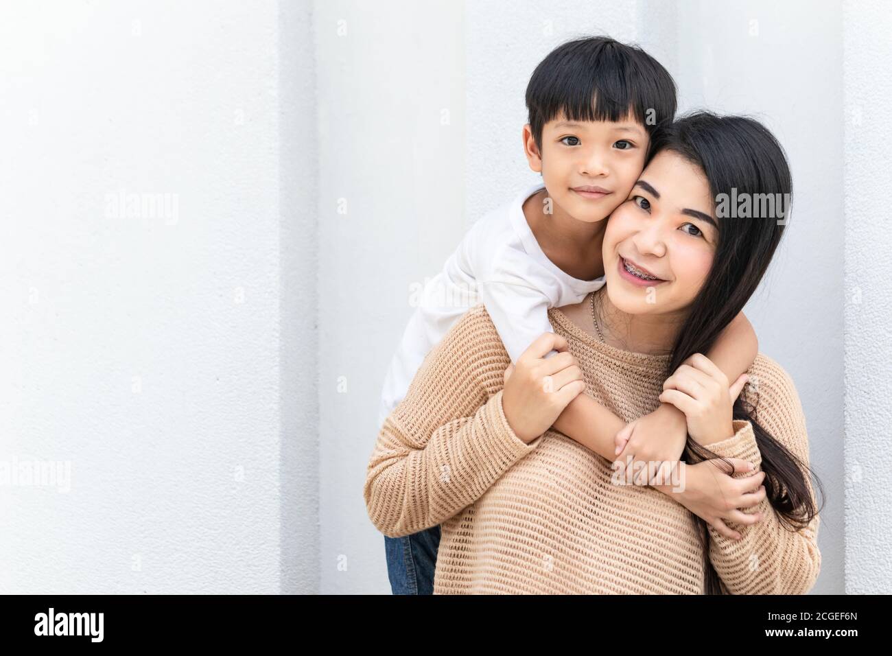Portrait schöne Mutter und Kind glücklich umarmt. Asiatische Familie Mutter und Kind sind umarmt und Blick auf die Kamera, niedlich und warm. Stockfoto