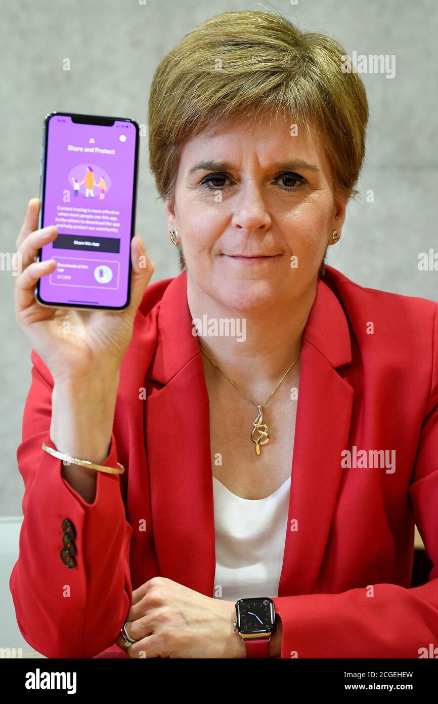 Erste Ministerin Nicola Sturgeon sieht die neue Track-and-Trace-App Covid-19 am Telefon im schottischen Parlament in Edinburgh. Stockfoto