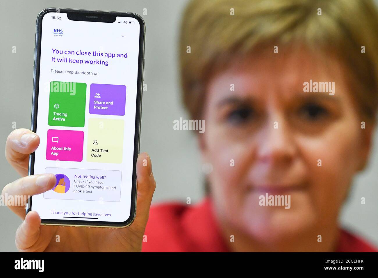 Erste Ministerin Nicola Sturgeon sieht die neue Track-and-Trace-App Covid-19 am Telefon im schottischen Parlament in Edinburgh. Stockfoto