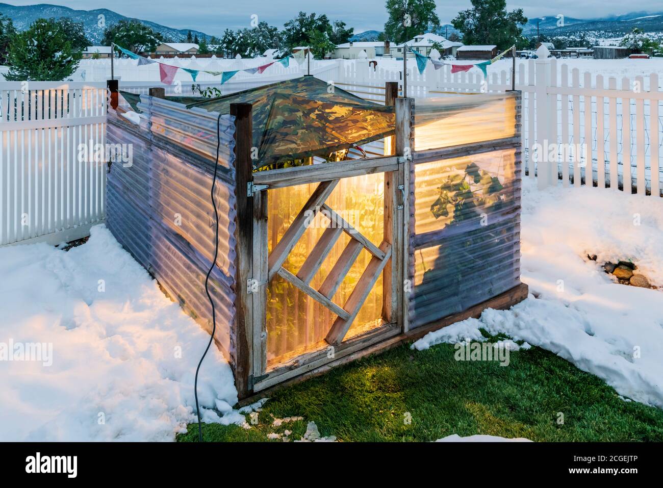 Dämmerung Blick auf Wohn Gemüsegarten mit temporären Plane bedeckt; helle Lampen verwendet, um einen frühen Saison Frost zu verhindern. Stockfoto