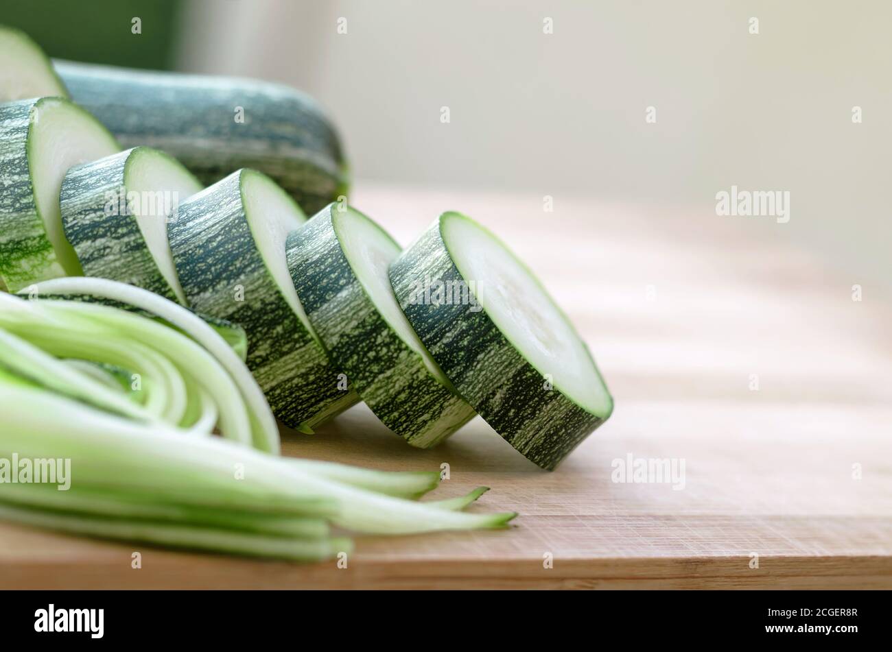 Roh geschnittene Zucchini auf einem Schneidebrett. Nahaufnahme, selektiver Fokus Stockfoto