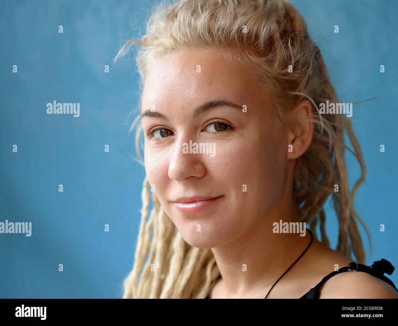 Junge kaukasische Frau mit blonden Dreadlocks Posen für die Kamera. Stockfoto