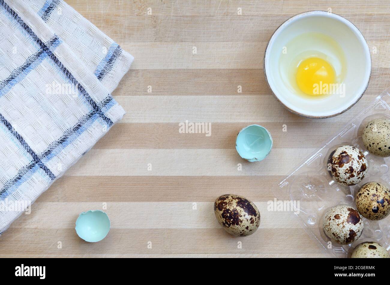 Wachtel Eier in den Prozess des Kochens auf einem hölzernen Schneidebrett mit einem Küchentuch Nahaufnahme mit einem Kopierplatz, Draufsicht. Gesunde Ernährung Konzept. Stockfoto