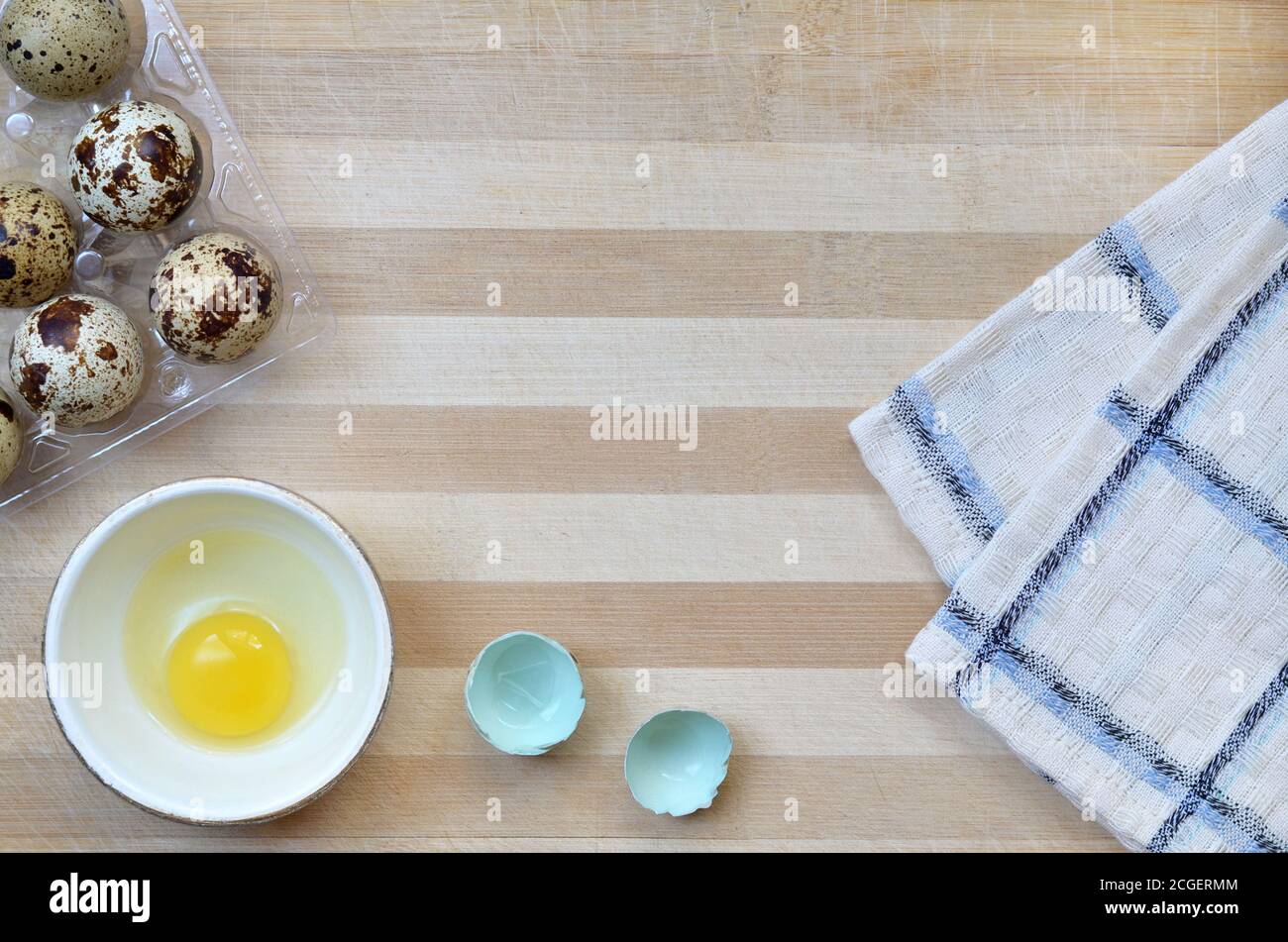 Wachtel Eier in den Prozess des Kochens auf einem hölzernen Schneidebrett mit einem Küchentuch Nahaufnahme mit Kopierraum, Draufsicht. Gesunde Ernährung Konzept. Stockfoto