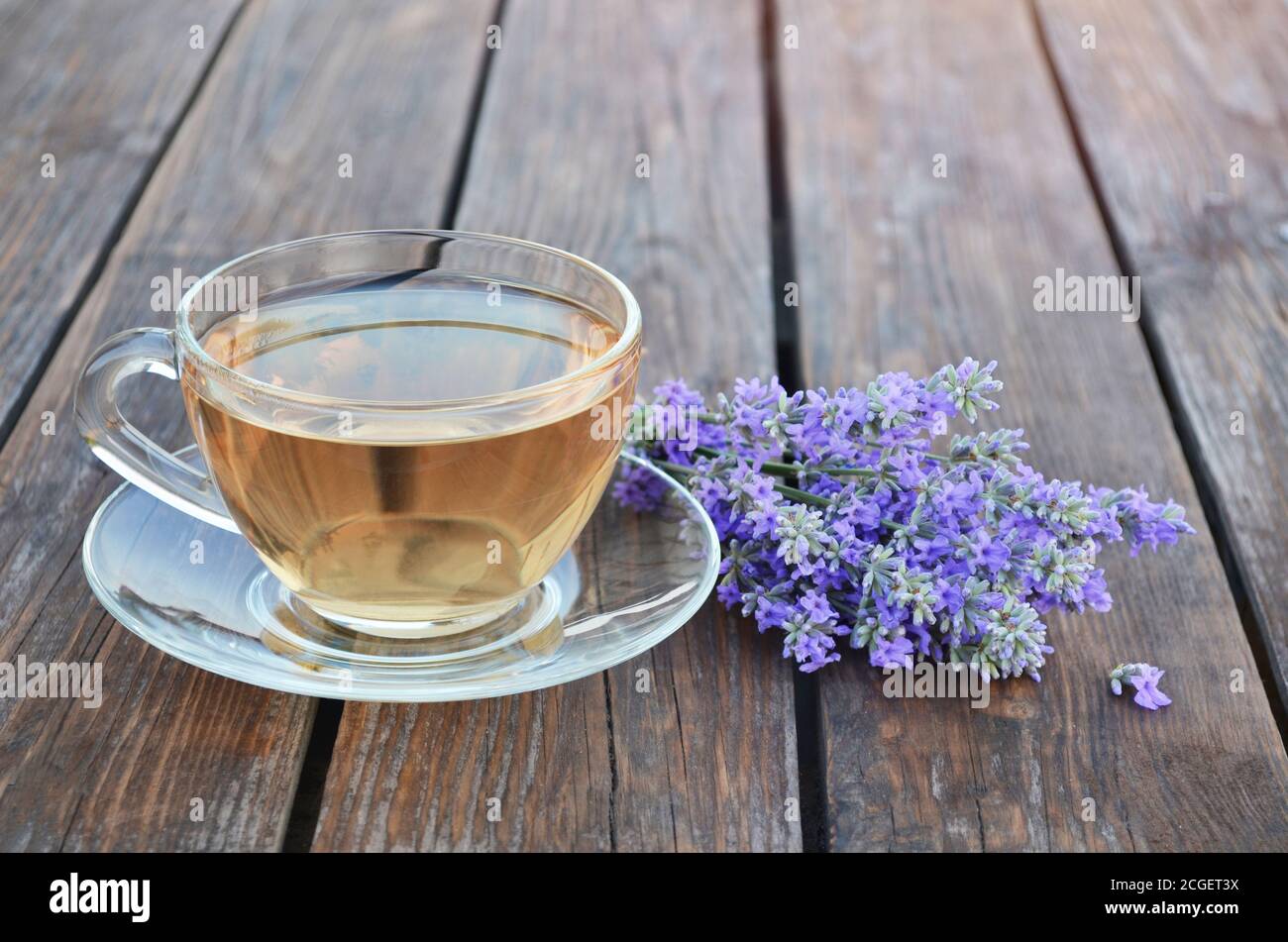 Tasse gesunden heißen Lavendeltee und Blumenstrauß einen Holztisch. Konzept eines gesunden Lebensstils. Stockfoto