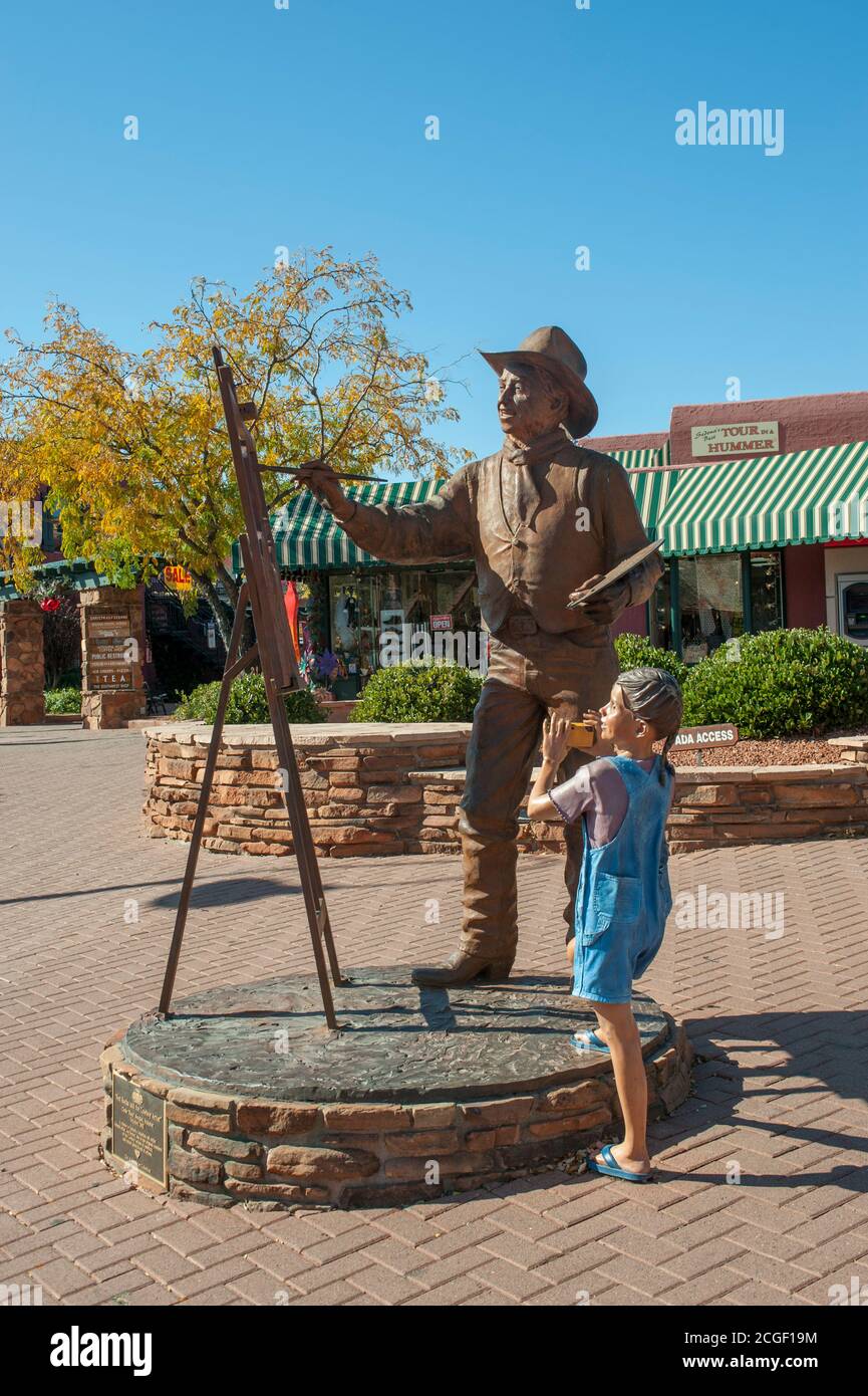 Eine Kunstskulptur eines Mädchens, das einen Maler in der Innenstadt von Sedona, Arizona, USA fotografiert. Stockfoto