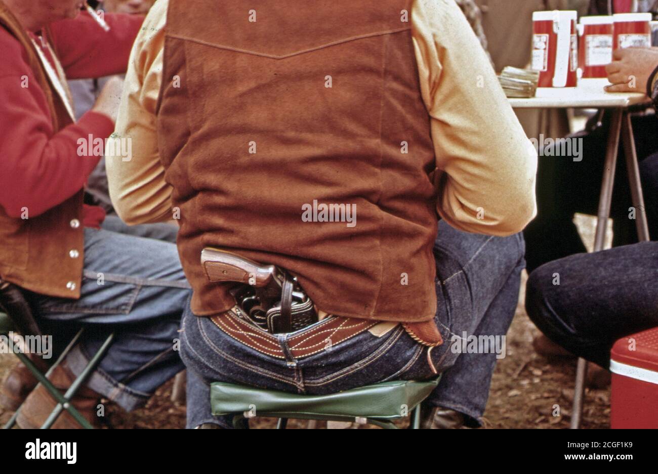 November 1972-A Deer Hunter trägt seine Pistole Während Poker Spielen an die Jäger' Camp. Er verwendet es Klapperschlangen im Wald zu töten, 11/1972 Stockfoto