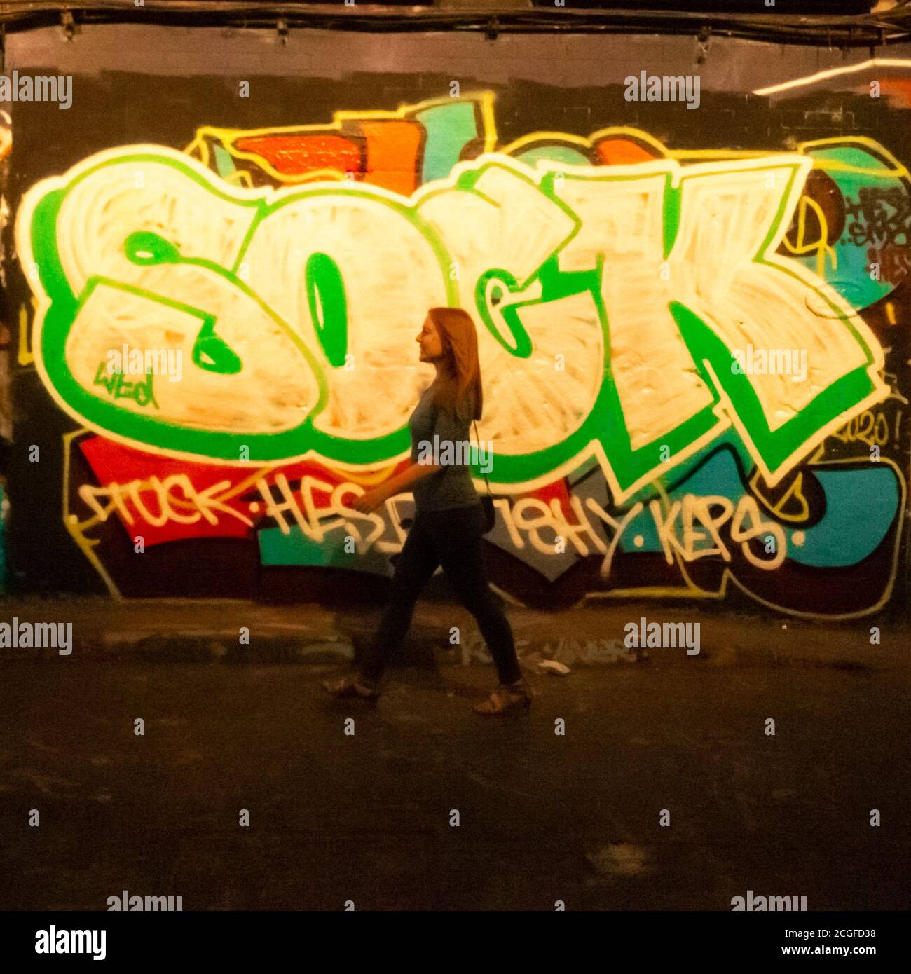 Frau, die vor Graffiti läuft Stockfoto