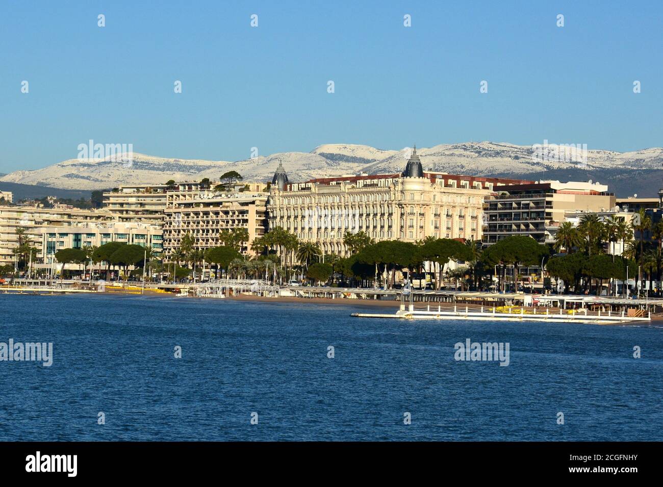 Frankreich, französische riviera, die Croisette Boulevard im Winter mit den verschneiten Hügeln im Hintergrund, in der Stadt des Internationalen Filmfestivals. Stockfoto
