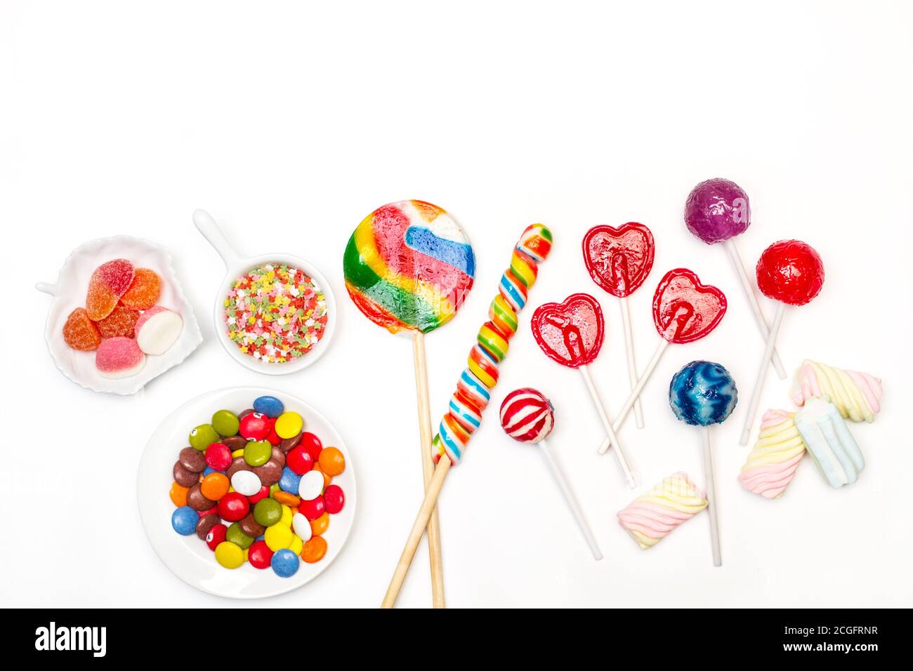 Verschiedene Bonbons und Lollipos auf weißem Hintergrund in einem Draufsicht Stockfoto