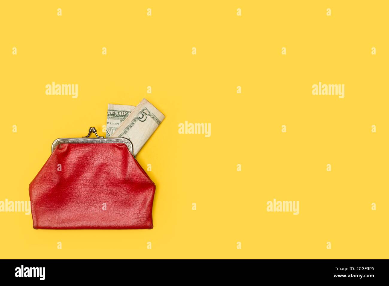 Alte rote Geldbörse mit einem 5-Dollar-Schein Ein gelber Hintergrund Stockfoto