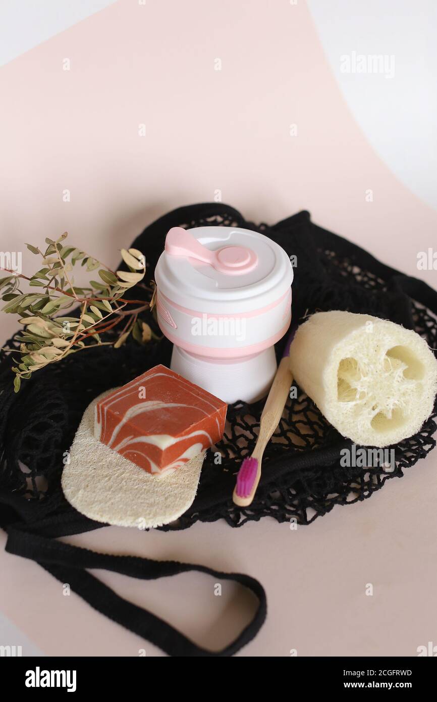 Holzzahnbürste, Flasche mit Öko Seife, natürlicher Loofah Schwamm auf Netzbeutel Hintergrund, Kopierplatz. Stockfoto
