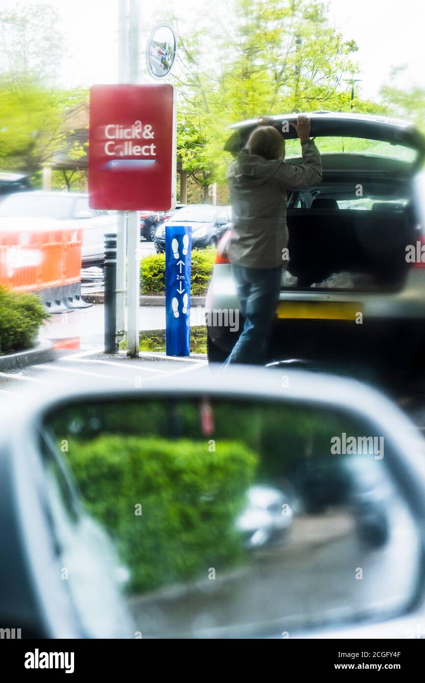 Autos, die in einem Supermarkt Schlange stehen, um während der Coronavirus-Pandemie 2020 in Großbritannien einkaufen zu können. Mit Schildern, die die Route zum Atke für den Click Adn Collect Service angeben. Stockfoto