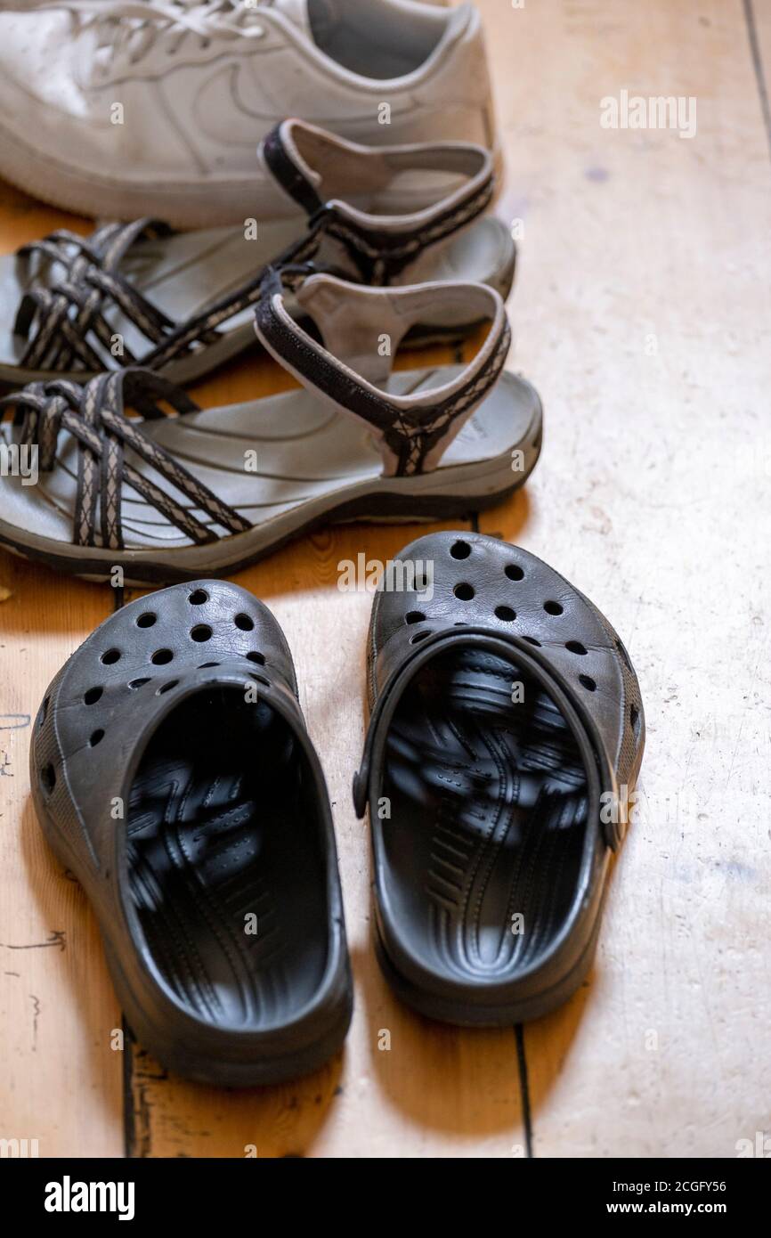 Ein Haufen Schuhe und Sandalen auf einem Flur Boden gelassen. Stockfoto