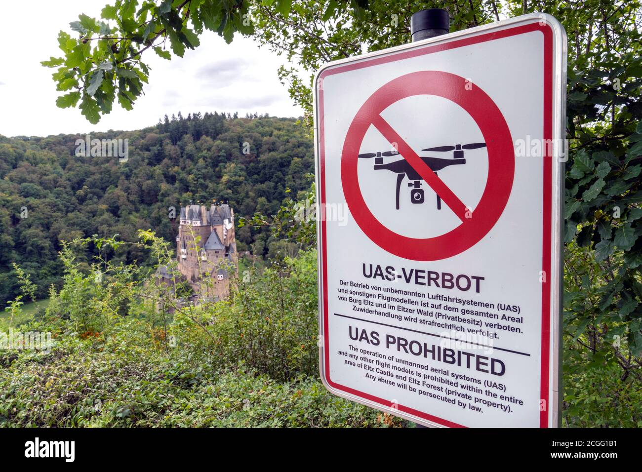 Ein Schild weist darauf hin, dass Drohnen (UAS = unbemannte Flugsysteme) nicht über Schloss Eltz (im Hintergrund) und den Elzerwald fliegen dürfen. Gemeinde Wierschem in Rheinland-Pfalz, Deutschland Stockfoto