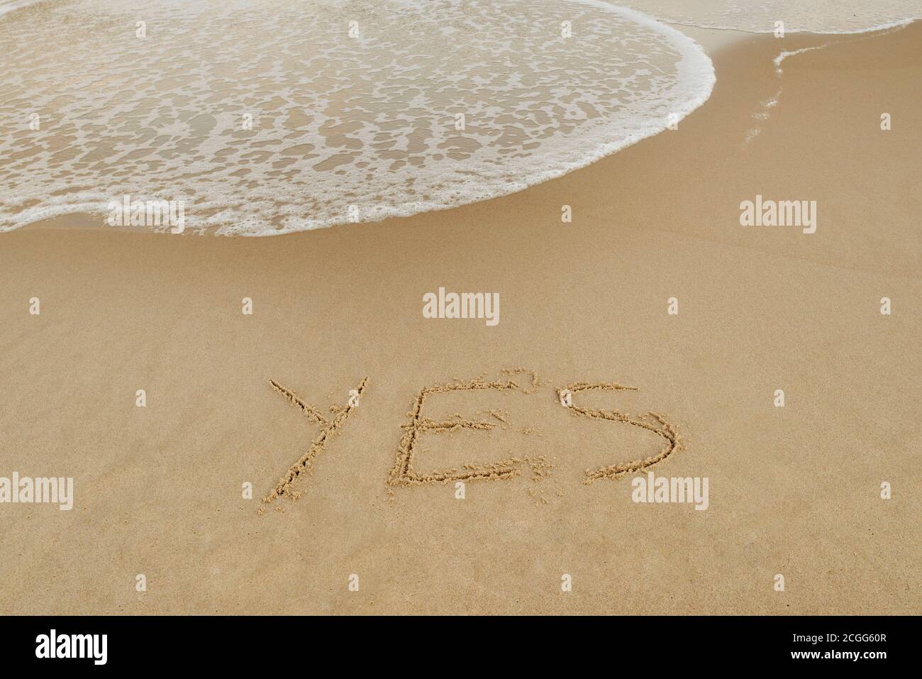 JA, Konzept, Wort geschrieben auf Sandstrand Stockfoto