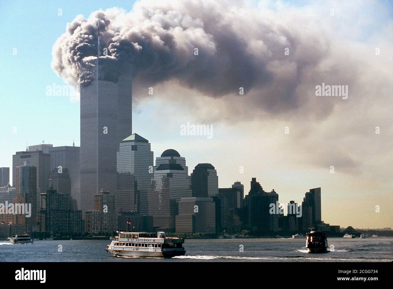Am Morgen des 11. September 2001 taucht dichter schwarzer Rauch aus den Türmen des World Trade Center im New Yorker Stadtteil Manhattan auf. Kurz zuvor waren zwei Flugzeuge hintereinander in die beiden Türme gerast. Abgesehen von den Insassen der Maschinen wurden die meisten Menschen in den beiden Wolkenkratzern bei den schweren Explosionen getötet. Das FBI geht unter dem Verdacht, dass es sich um einen gezielten Angriff von terroristischen Selbstmordattentätern handelt. Die oberen Teile der Wolkenkratzer gingen nach Explosionen in Flammen auf. Teile der Trümmer und Gebäude der 411 Meter hohen Zwillingstürme flogen auf die Straße. Th Stockfoto