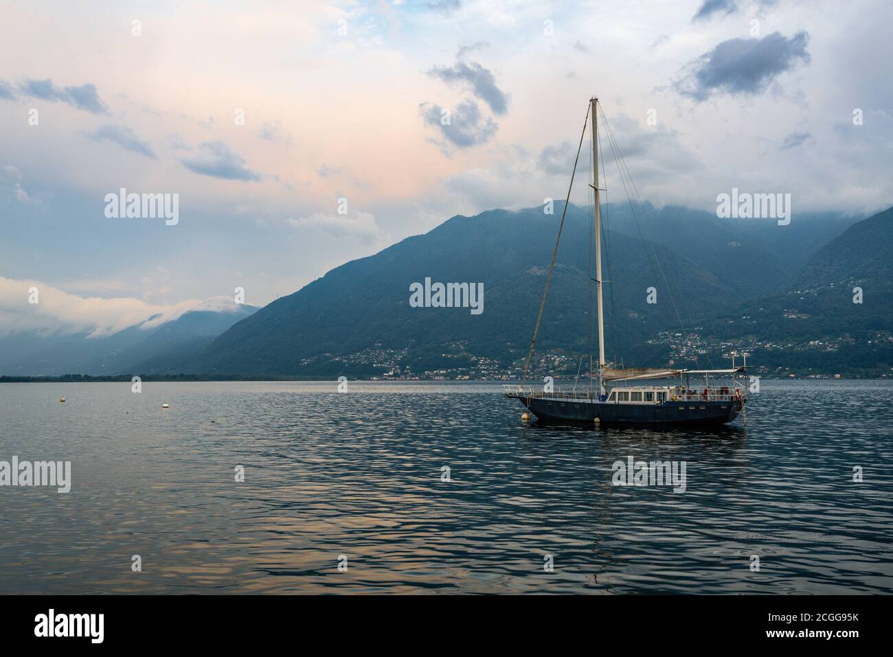Segelboot in der Mitte des Lago Maggiore in der Abenddämmerung Die Grenze zwischen Italien und der Schweiz Stockfoto