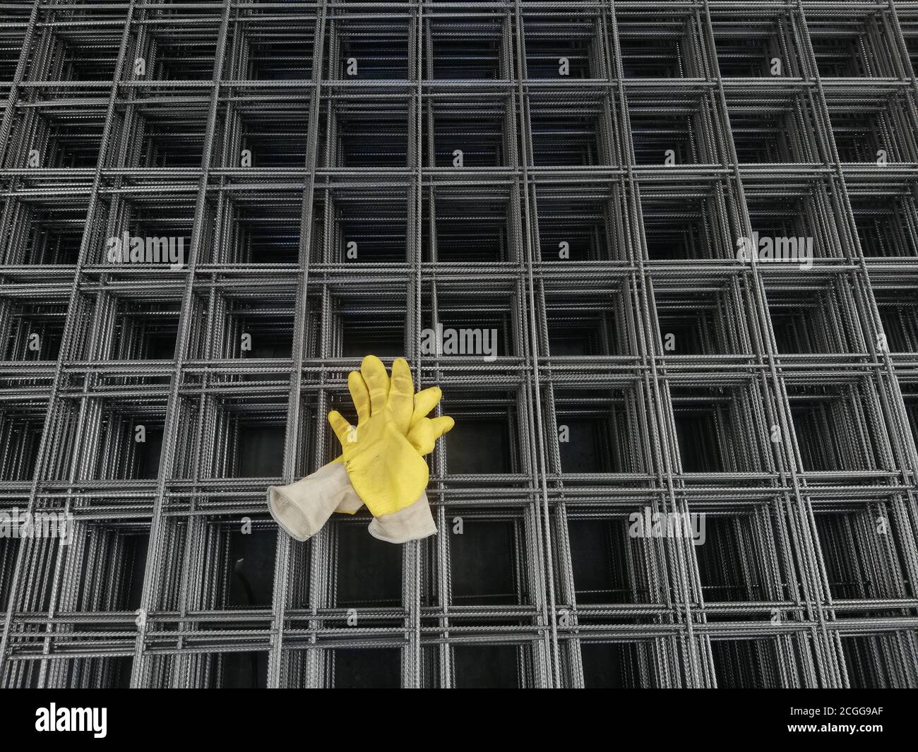 Gelbe Handschuhe stehen auf eisernem Hintergrund Stockfoto