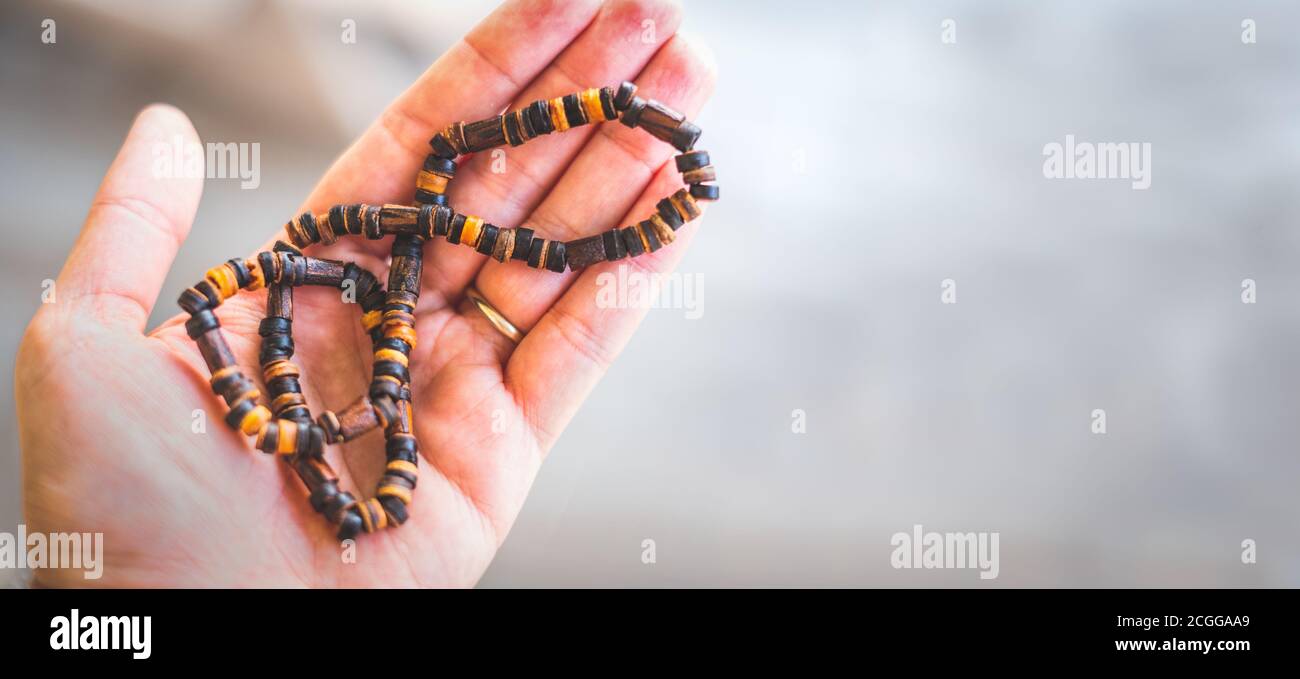 Mann Hand halten Halskette traditionellen Holz horizontalen Hintergrund Stockfoto