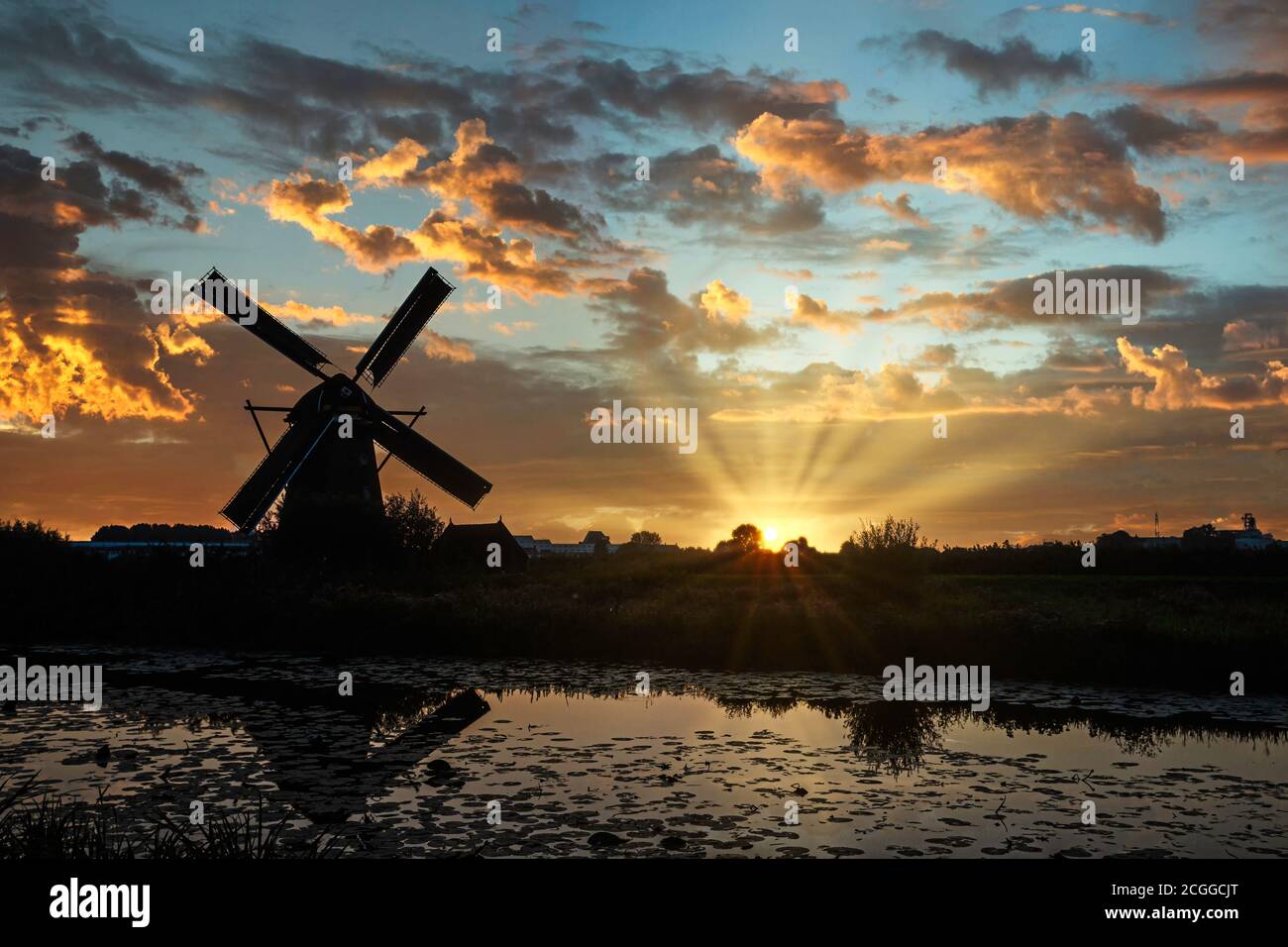 Sonnenuntergang auf der Kinderdijk Windmühlen Silhouette reflektiert auf dem ruhigen Kanalwasser, Niederlande Stockfoto