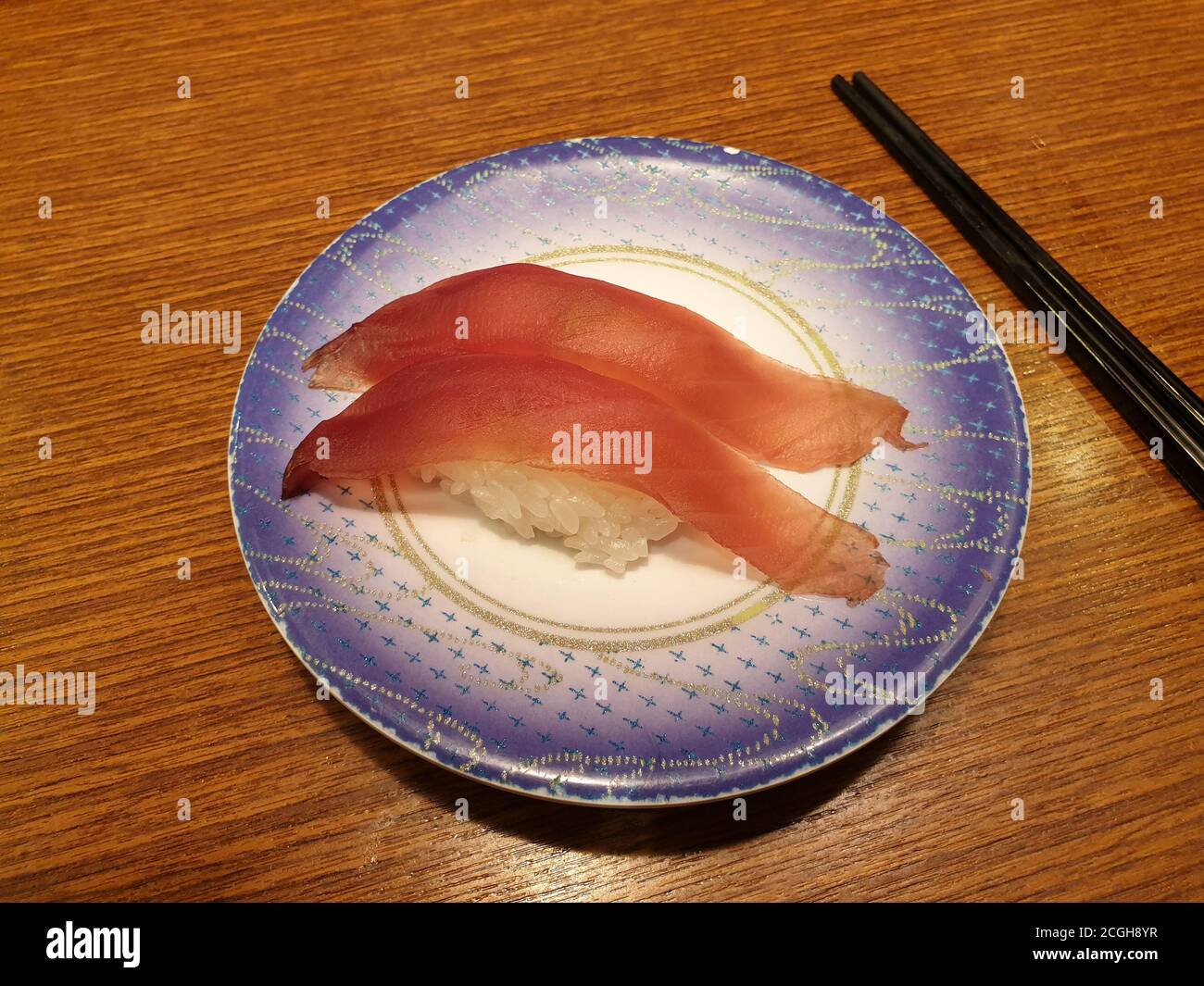 Thunfisch-Sushi auf kleinem Teller. Beliebtes Sushi-Restaurant mit Förderband in Seoul. Stockfoto