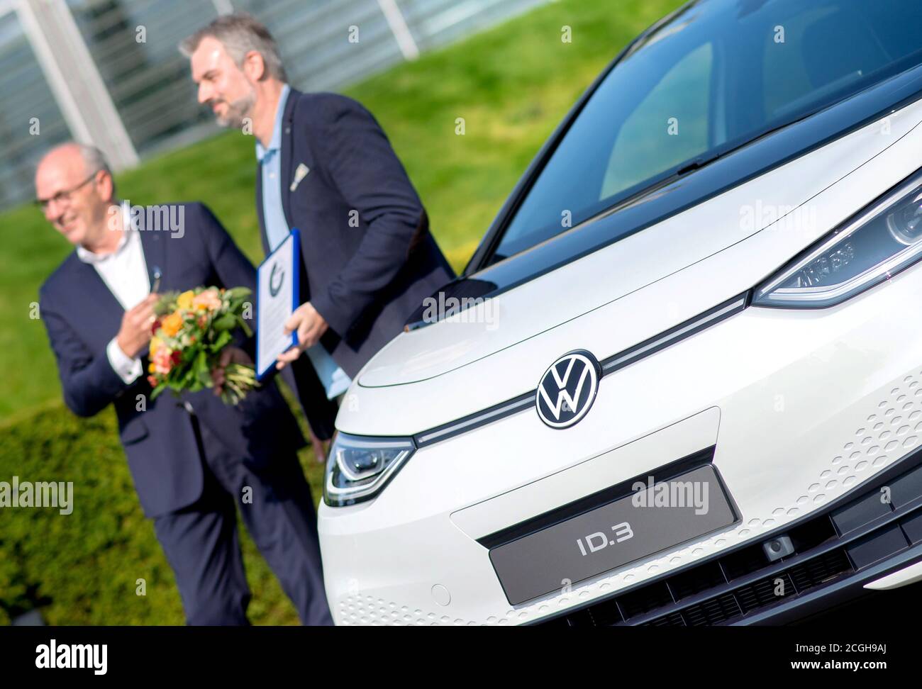 Wolfsburg, Deutschland. September 2020. Oliver Nicolai (r), einer der ersten Kunden, erhält seinen neuen VW ID.3 von Jürgen Stackmann (l), Mitglied des Vorstands der Marke Volkswagen, bei einer Presseveranstaltung zur Auslieferung der ersten Volkswagen Elektroautos in der Autostadt. Dies sind die ersten von rund 22 Millionen Fahrzeugen, die bis 2028 weltweit auf Basis der neuen E-Drive-Plattform produziert und ausgeliefert werden. Quelle: Hauke-Christian Dittrich/dpa/Alamy Live News Stockfoto