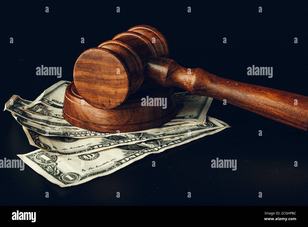 Hölzerner Richter Gavel auf US-Dollar-Banknoten Nahaufnahme. Konzept der Justizkorruption Stockfoto