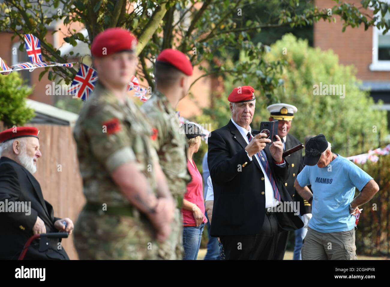 Aktuelle und ehemalige Mitglieder der Militärpolizei bilden eine Ehrenwache für die ehemalige Krankenschwester und Veteran des Zweiten Weltkriegs Joan Rich, als sie das Finale von 102 Runden im Allenby Park, Felixstowe, beendet, um an ihrem 102. Geburtstag Geld für NHS-Wohltätigkeitsorganisationen zu sammeln. Stockfoto