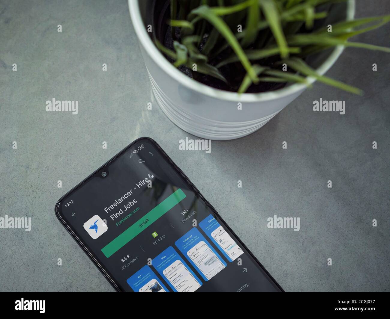 LOD, Israel - 8. Juli 2020: Moderner minimalistischer Büroarbeitsplatz mit schwarzem Smartphone mit Freelancer App Play Store Seite auf Marmor Hintergrund. Stockfoto
