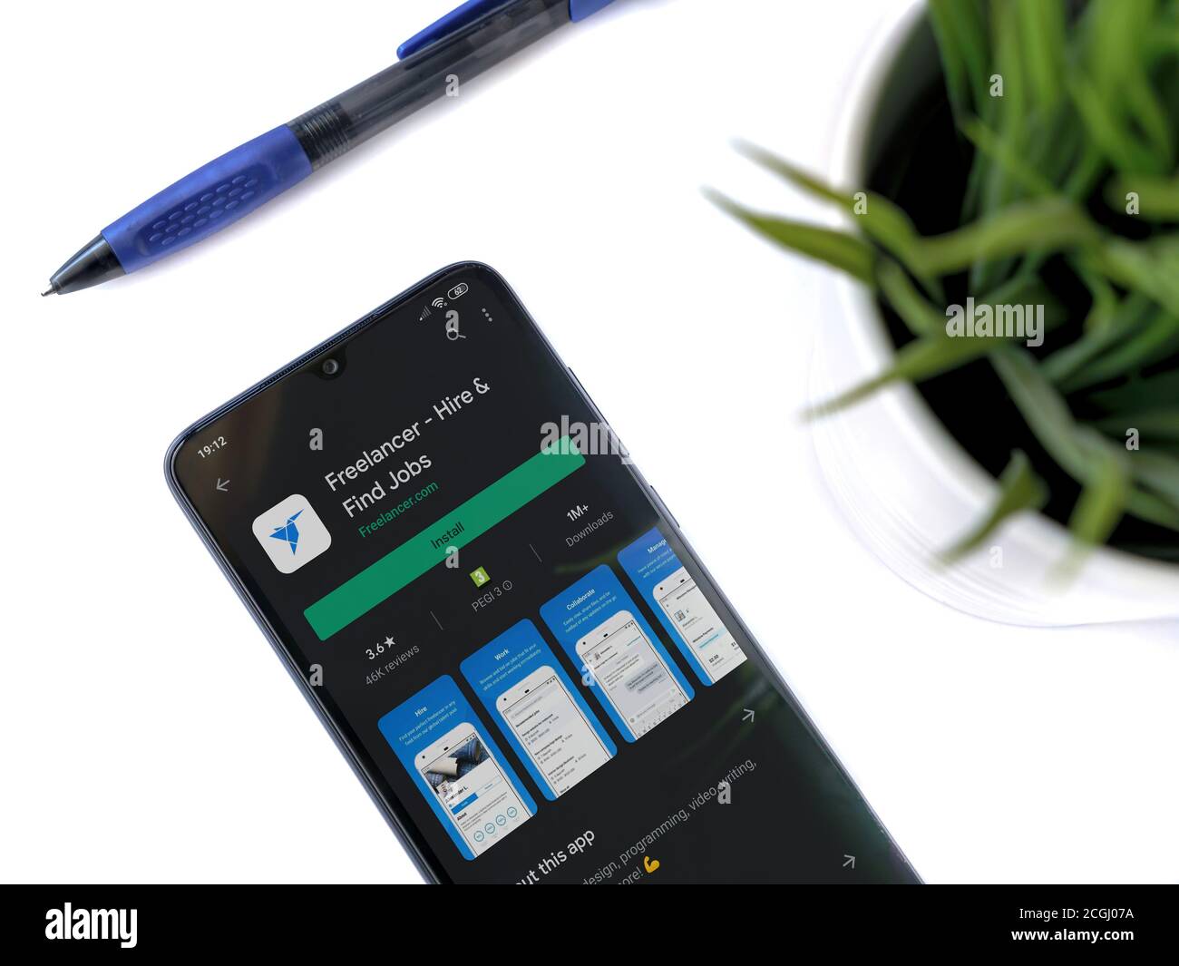 LOD, Israel - 8. Juli 2020: Moderner minimalistischer Büroarbeitsplatz mit schwarzem Smartphone mit Freelancer App Play Store Seite auf weißem Hintergrund. T Stockfoto