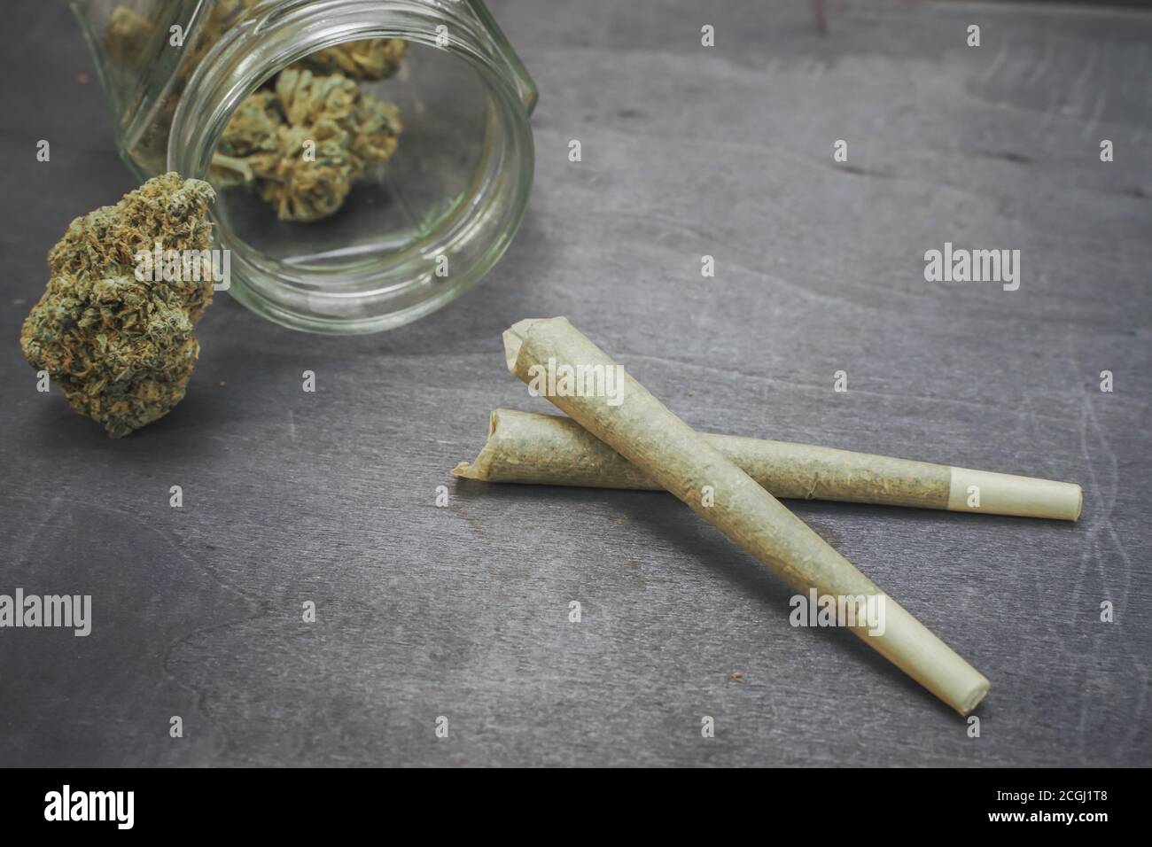 Vorgerolltes medizinisches CBD-Marihuana und Hanfblätter auf schwarzem Holzhintergrund. Organische und natürliche Kosmetik- und Kosmetikprodukte auf Hanfbasis. Cannabis. Stockfoto