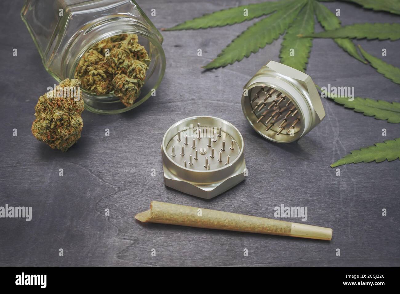 Vorgerolltes medizinisches CBD-Marihuana und Hanfblätter auf schwarzem Holzhintergrund. Organische und natürliche Kosmetik- und Kosmetikprodukte auf Hanfbasis. Cannabis. Stockfoto