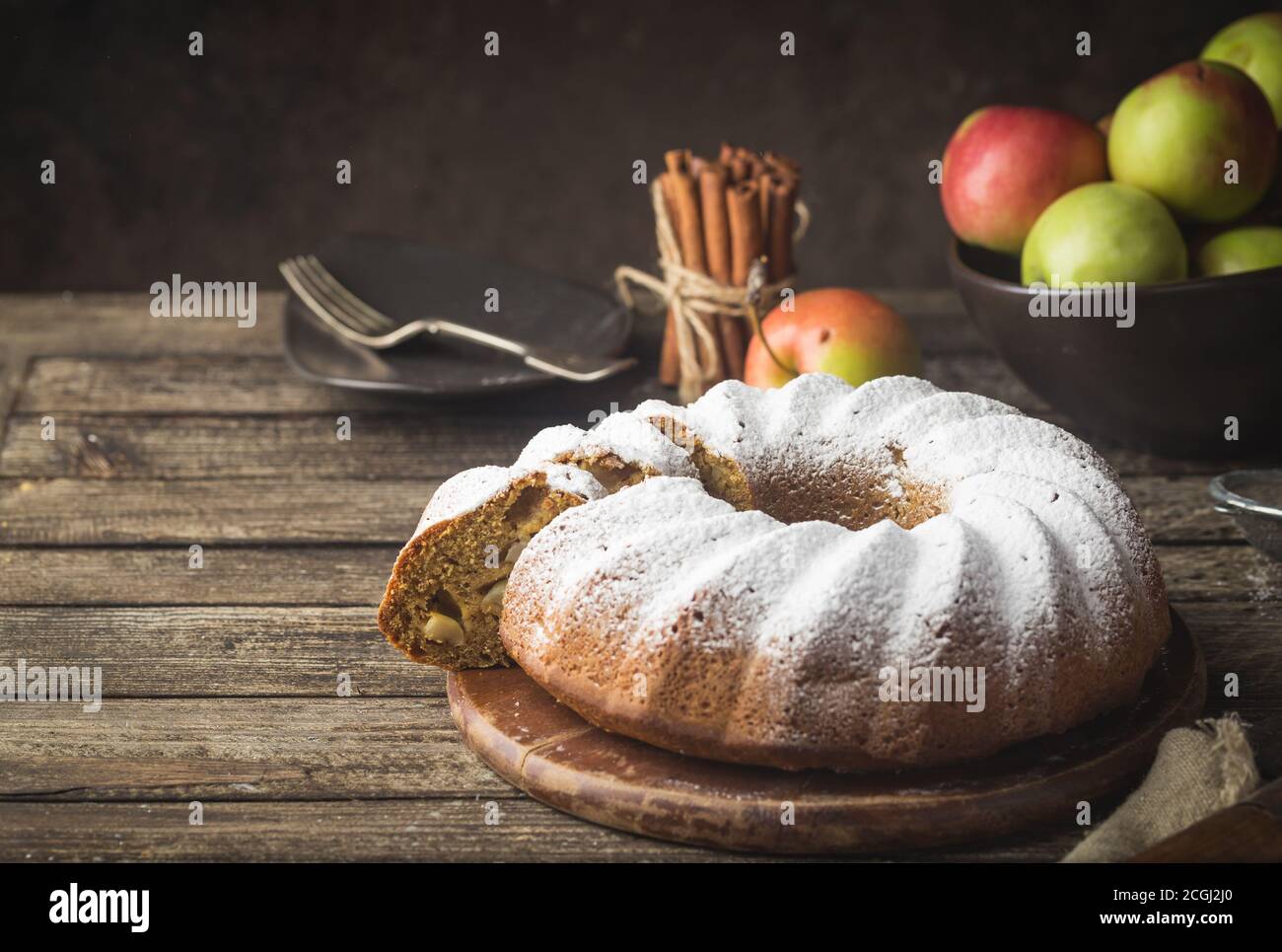 Landhausstil Apple Bundt Cake bestreut mit Puderzucker auf alten Holztisch Stockfoto